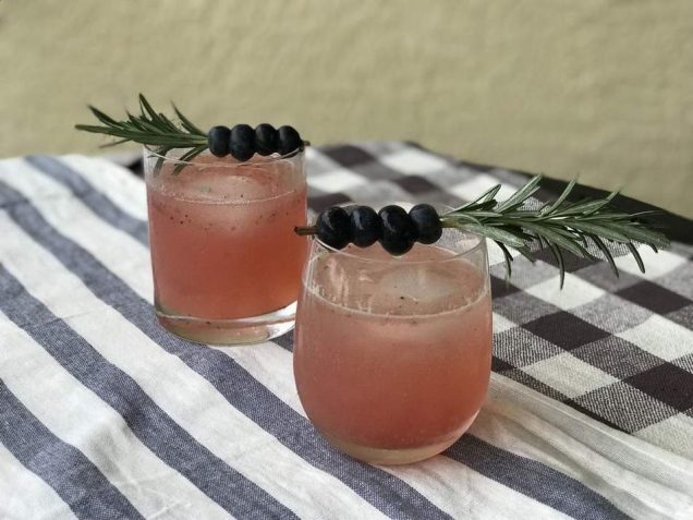 Two glasses of pink drink with sprigs of rosemary served at a trendy apartment in Fayetteville, NC.