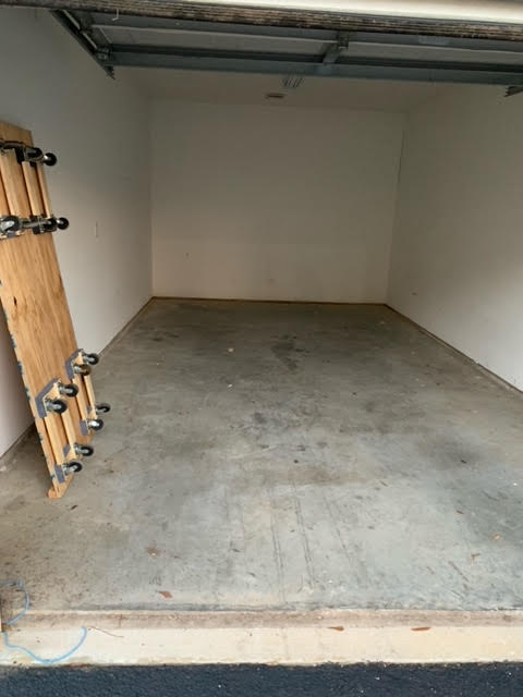 An empty garage with a skateboard on the floor, available for rent in Fayetteville.