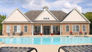 Apartments in Fayetteville, North Carolina - Pool & Patio with Lounge Chairs and View to Clubhouse